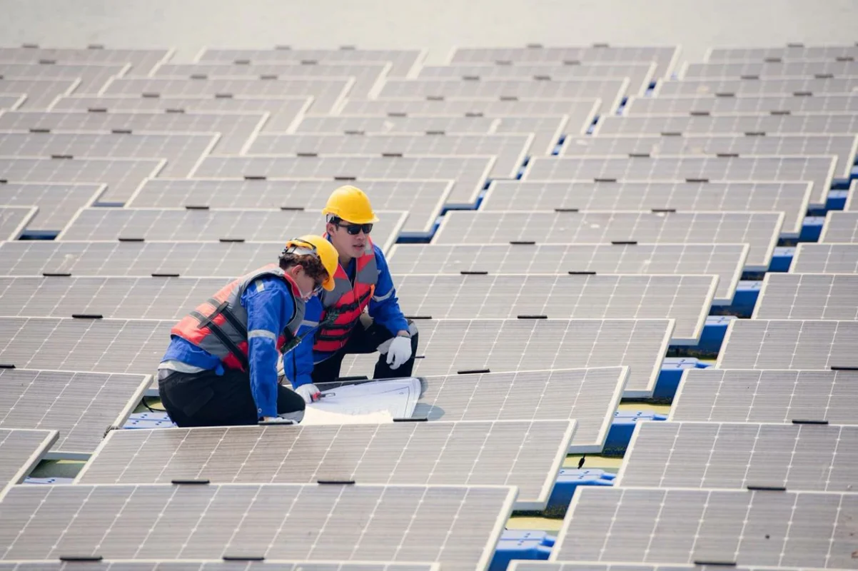 Due tecnici studiano i progetti per il revamping di un impianto fotovoltaico galleggiante.