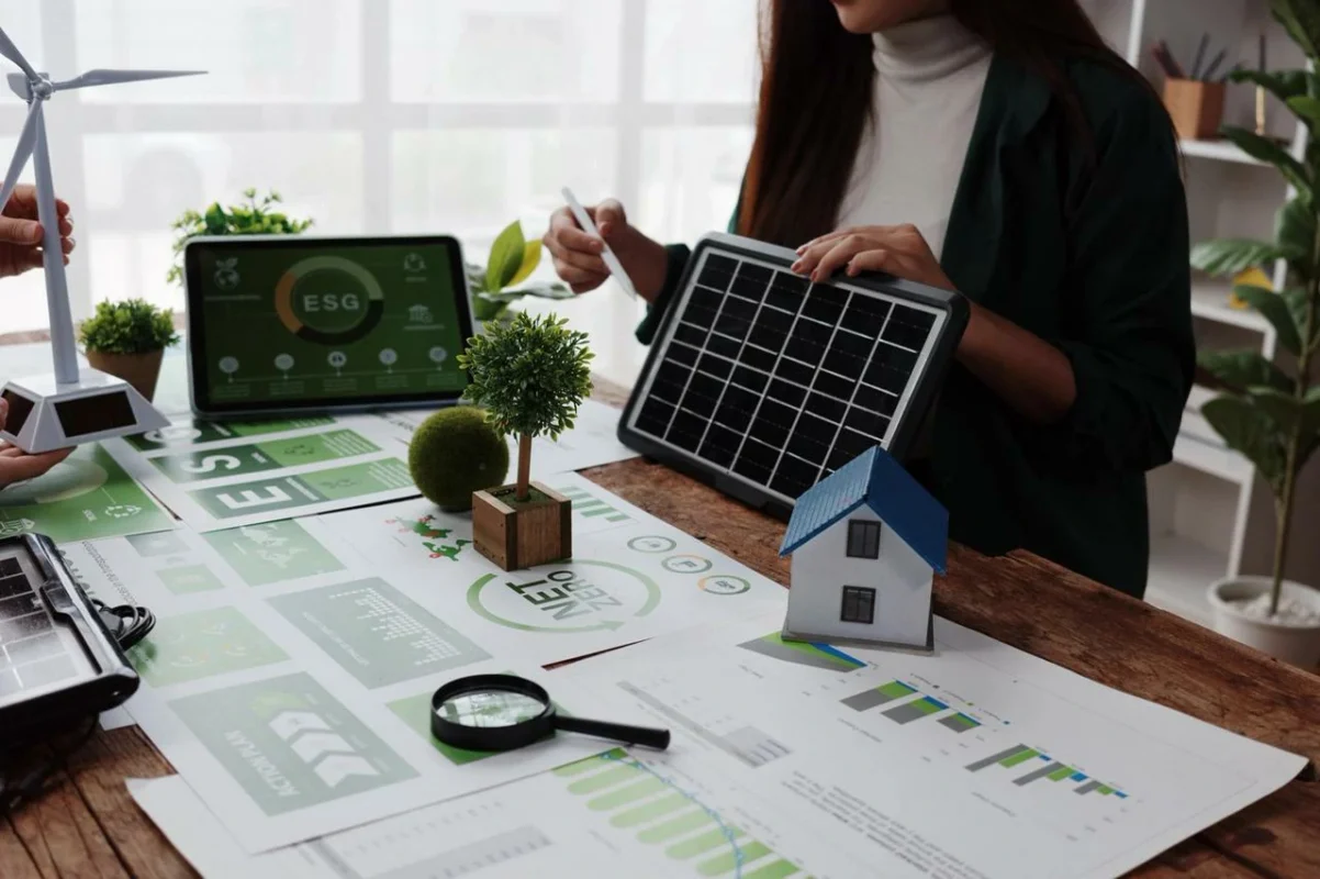 Analisi del ROI fotovoltaico industriale con pannelli e documenti ESG su un tavolo, per la pianificazione sostenibile.