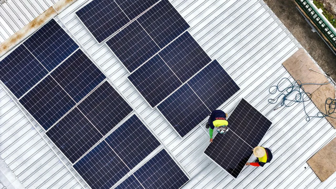 Operai installano nuovi pannelli fotovoltaici sul tetto durante un intervento di revamping.