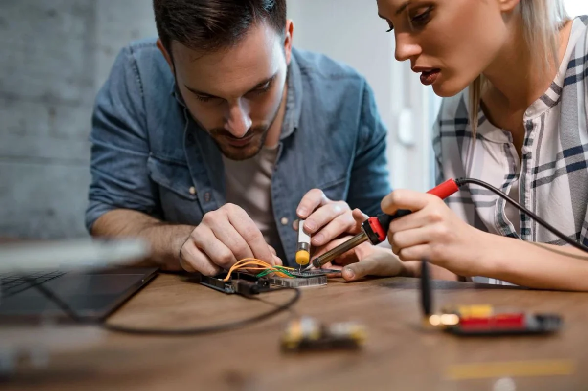 Tecnici specializzati in certificazione installatore fotovoltaico, riparano componenti elettronici in laboratorio, garantendo la qualità del sistema.