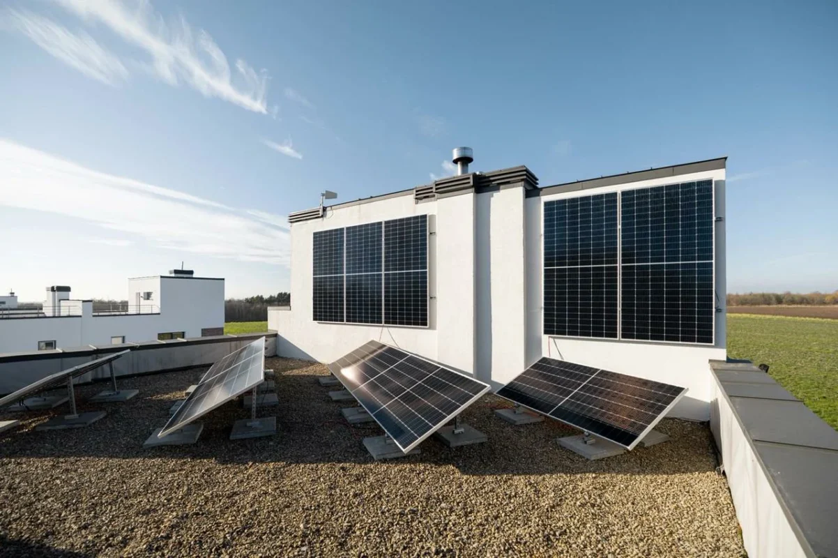 Pannelli solari montati sulla facciata e sul tetto di un edificio moderno, catturando la luce solare per alimentare la struttura e supportare il controllo intelligente dei carichi energetici.