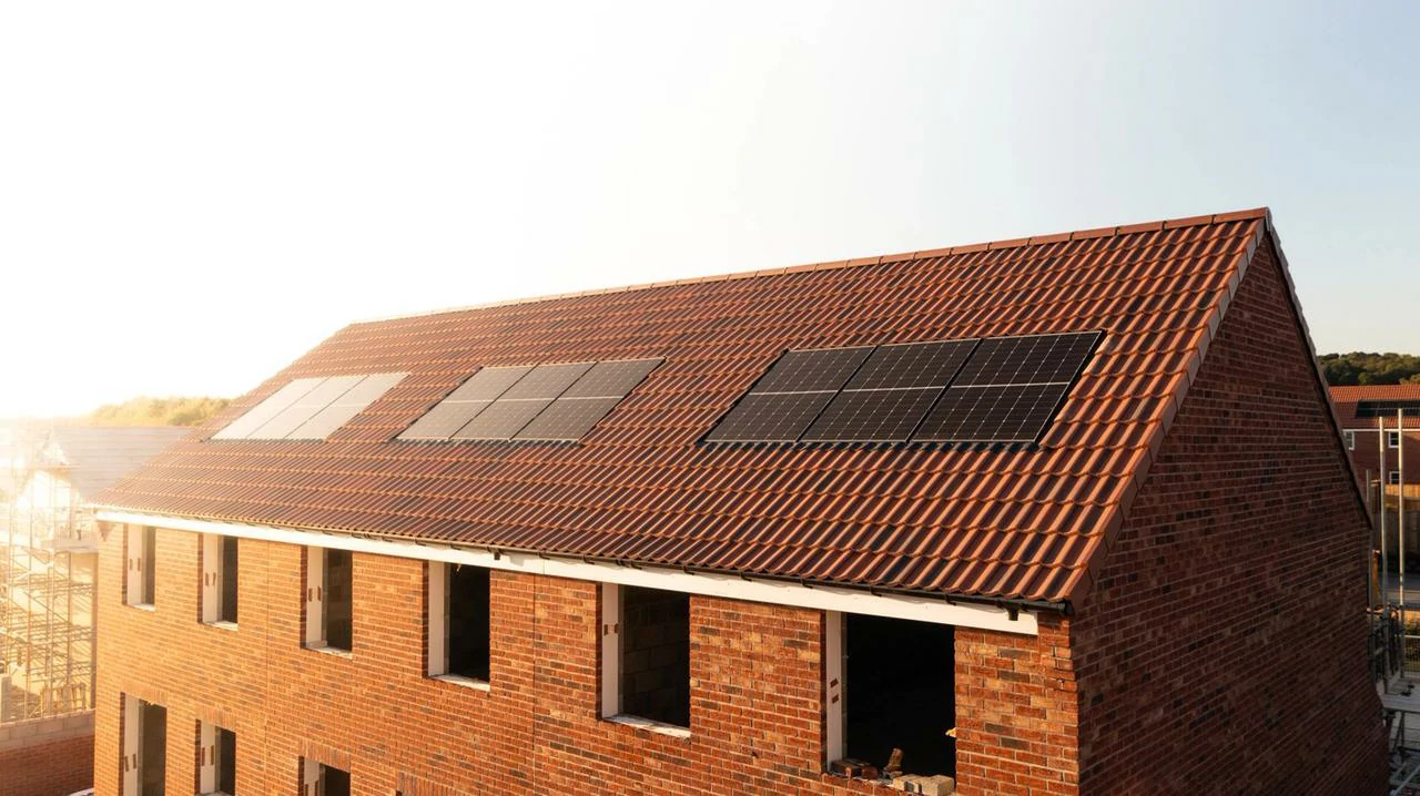 Pannelli fotovoltaici installati sul tetto di una casa in costruzione, per la produzione di energia e il mantenimento di un inverter efficiente e raffreddato.