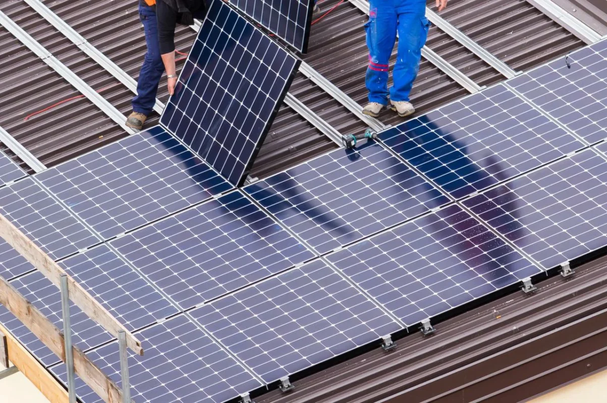 Operai posizionano un pannello fotovoltaico rispettando le normative antincendio.