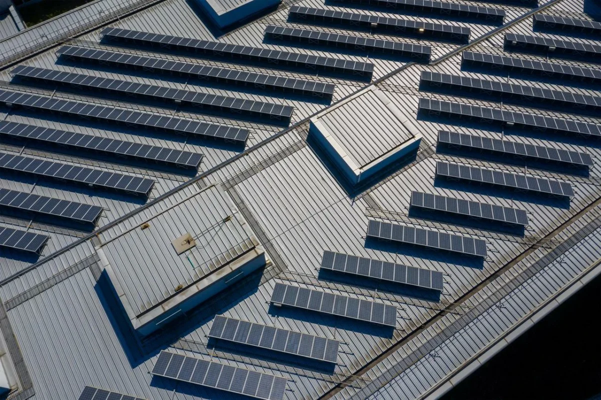 Vista aerea di pannelli fotovoltaici su tetto, con layout conforme alle normative antincendio.