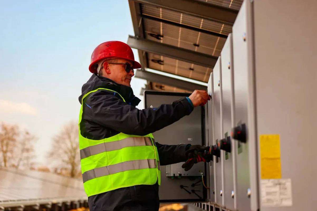 Un operatore regola i comandi di un inverter certificato per assicurare il rispetto delle normative.