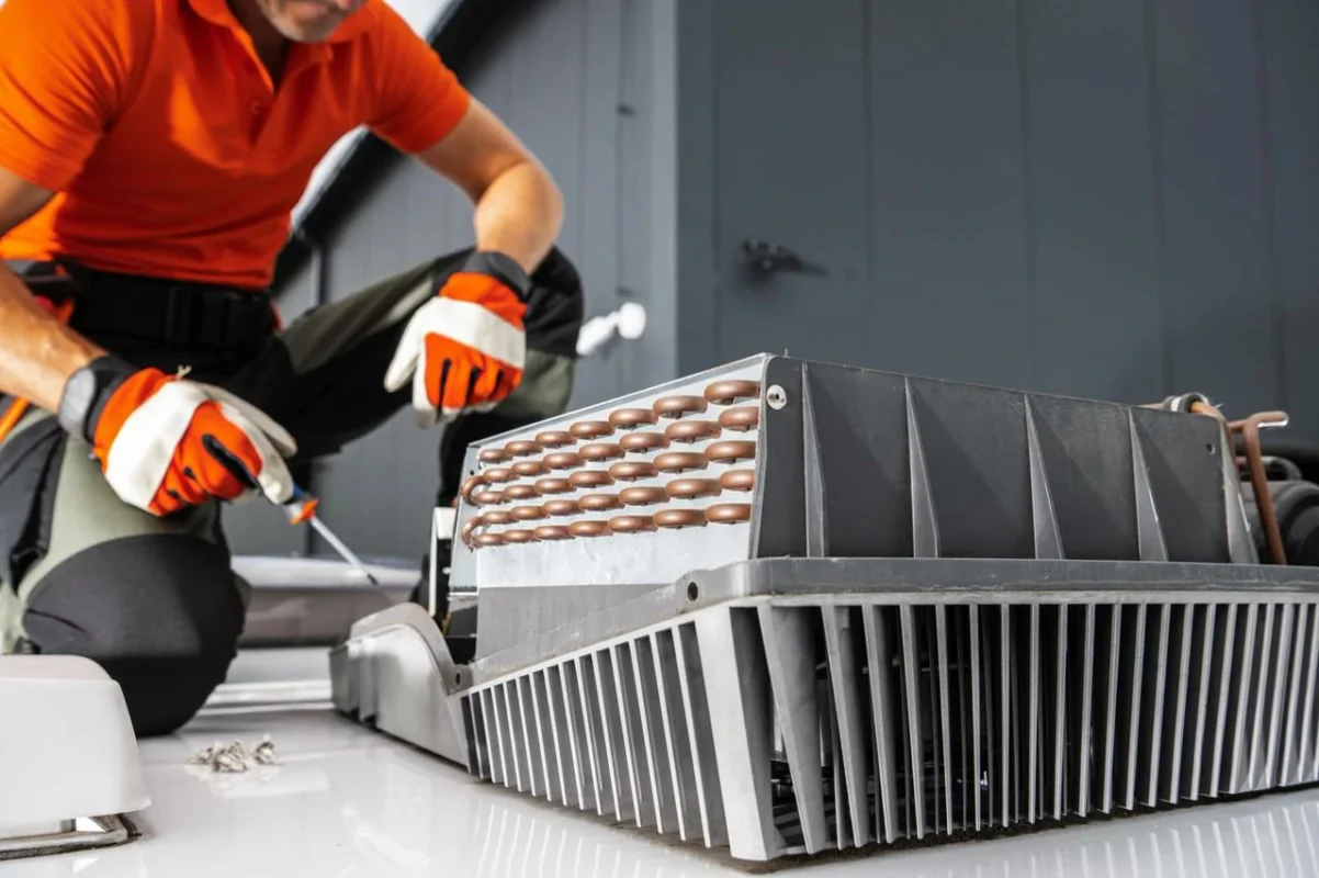 Tecnico specializzato che ripara un'unità di raffreddamento, fondamentale per mantenere l'efficienza e la durata di un inverter fotovoltaico.