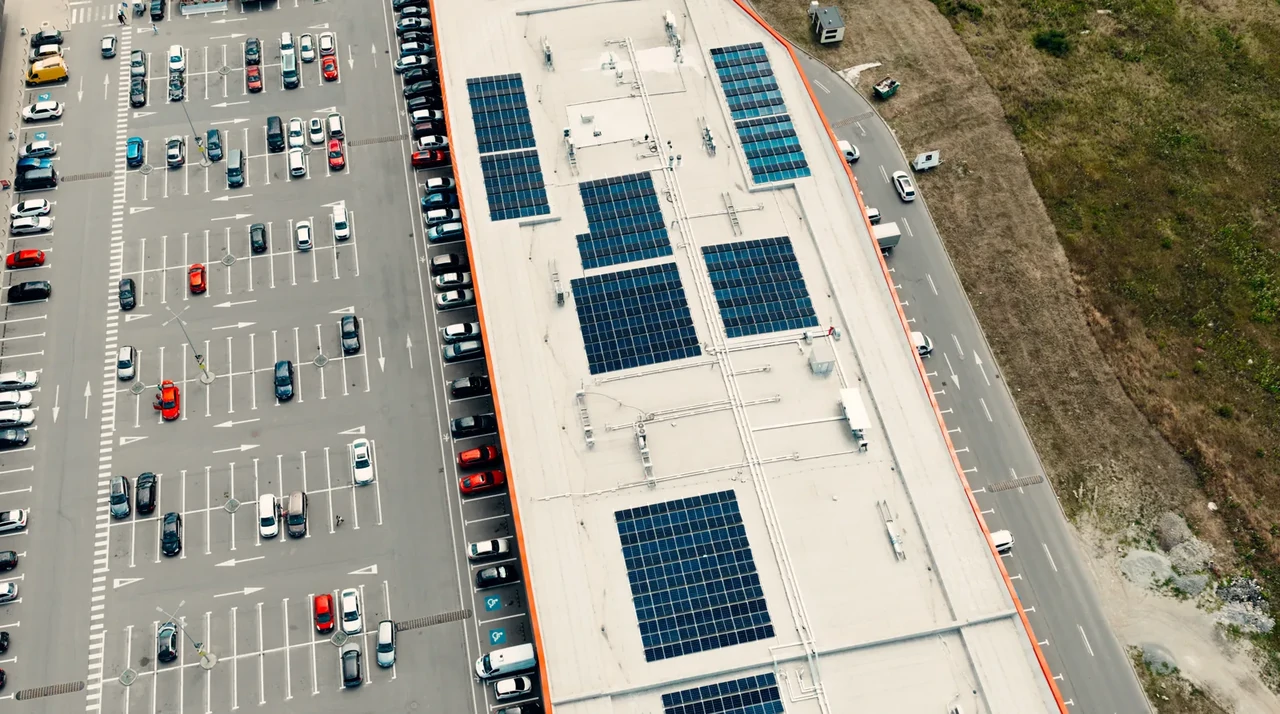 Tecnico con tablet ispeziona l'armadio di controllo di un impianto fotovoltaico da 20kW, monitorando i parametri dell'inverter.