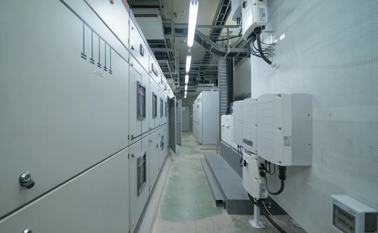 Sala tecnica con inverter fotovoltaici trifase installati a parete e quadri elettrici.