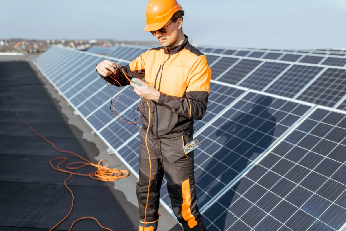 Tecnico specializzato verifica l'impianto fotovoltaico su tetto: fase di controllo e studio di fattibilità prima della scelta dell'inverter e della definizione del progetto.