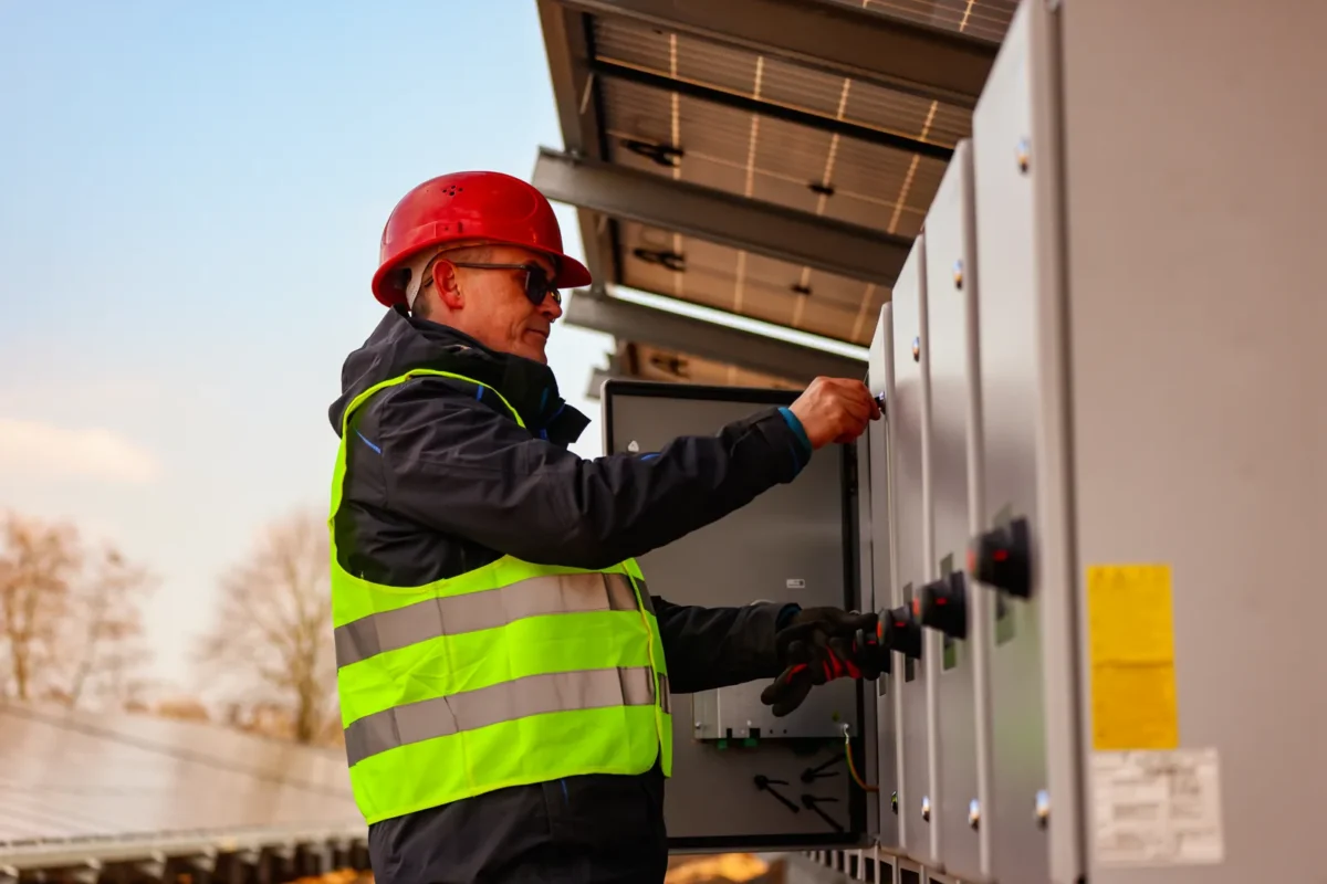 Tecnico manutiene inverter sistema all-in-one accumulo trifase su impianto fotovoltaico commerciale