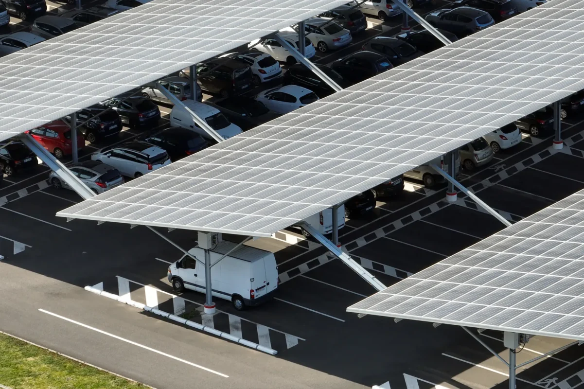 Tettoie con pannelli solari per ombreggiare il parcheggio con veicoli elettrici, soluzione per il risparmio energetico.