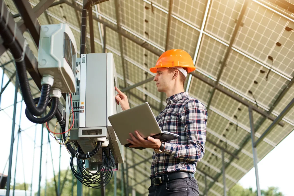 A technician configures an affordable hybrid inverter at a commercial solar site.