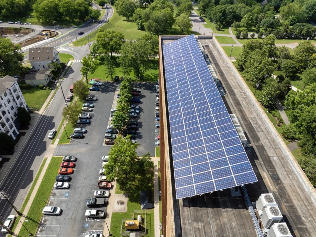 Vista aérea de um grande painel solar instalado no telhado de um prédio residencial, um projeto de energia renovável no segmento B2B.