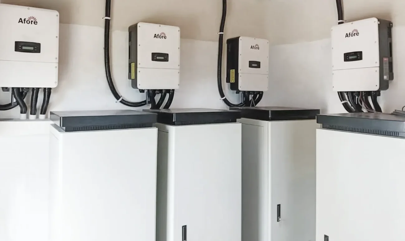 Four wall-mounted Afore hybrid inverters are neatly wired above vertical battery storage cabinets to build a complete solar hybrid energy system.