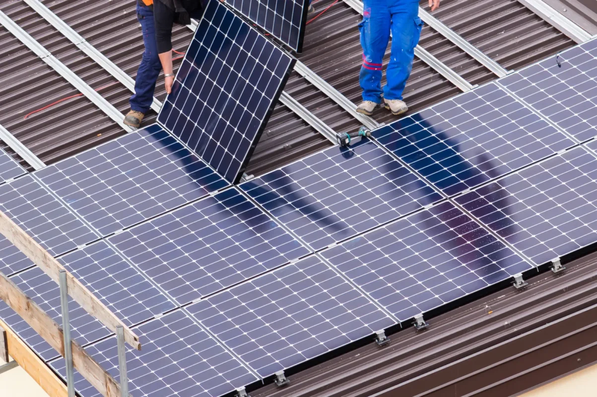 Workers install solar panels on new homes as part of B2B solar solutions.